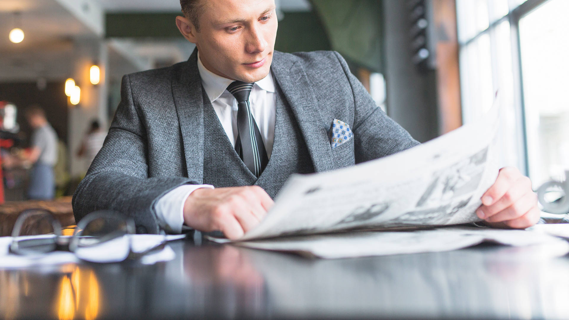 businessman-reading-newspaper-caf